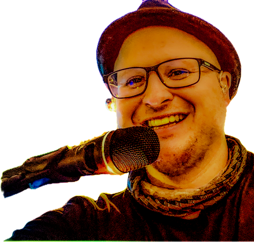 Mann mit Brille und Hut lächelt in ein Mikrofon.